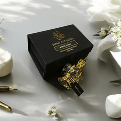 Elegant White Oud perfume bottle and packaging by Jamal Al Muslim, surrounded by decorative flowers and stationery.