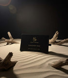 Mega Deal Musk Discovery Box displayed on sand with driftwood accents, showcasing premium concentrated musk oils.