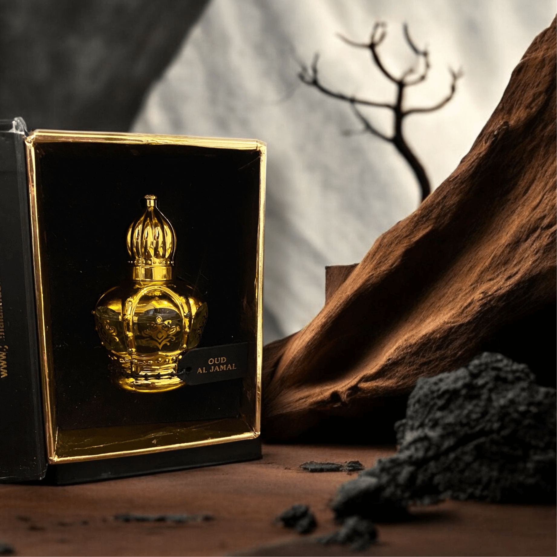 Oud Al Jamal 12ml perfume bottle showcased in a luxurious box with an artistic background.