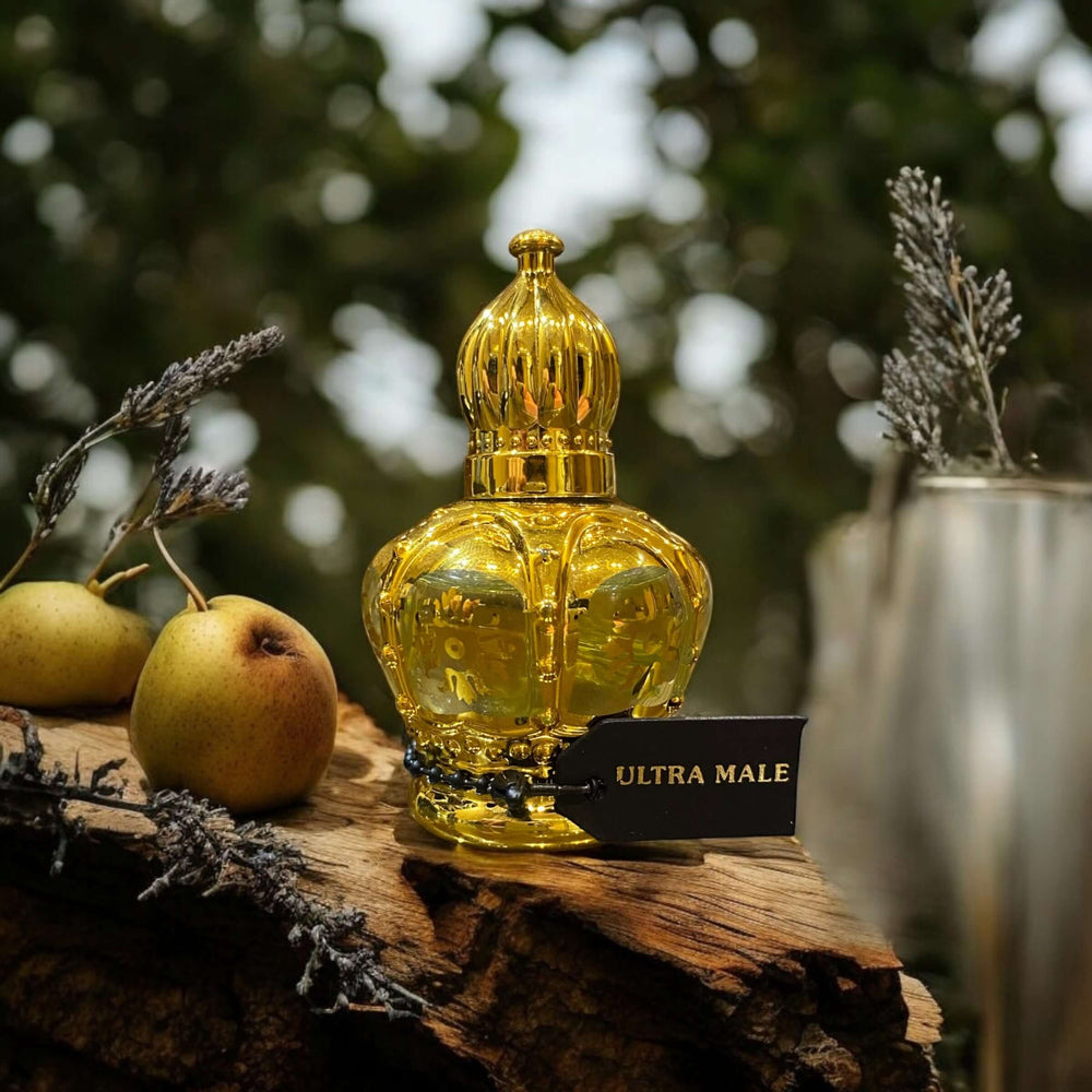 Ultra Male Perfume Oil bottle on wood, surrounded by apples and greenery, showcasing its seductive fragrance.
